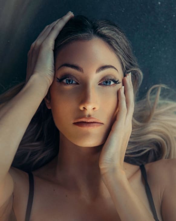 Woman Laying down while touching her face