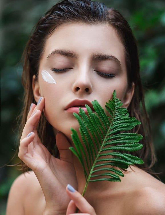 Woman holding a flower with her eyes closed