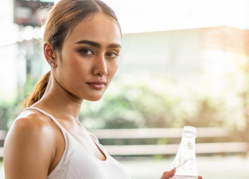 Photo of woman holding a bottle of water to stave off dehydration