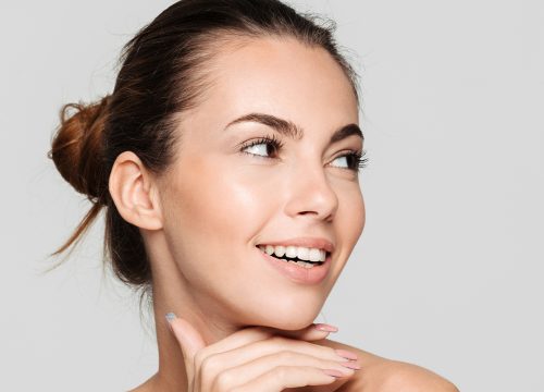 Photo of a brunette woman against a gray background