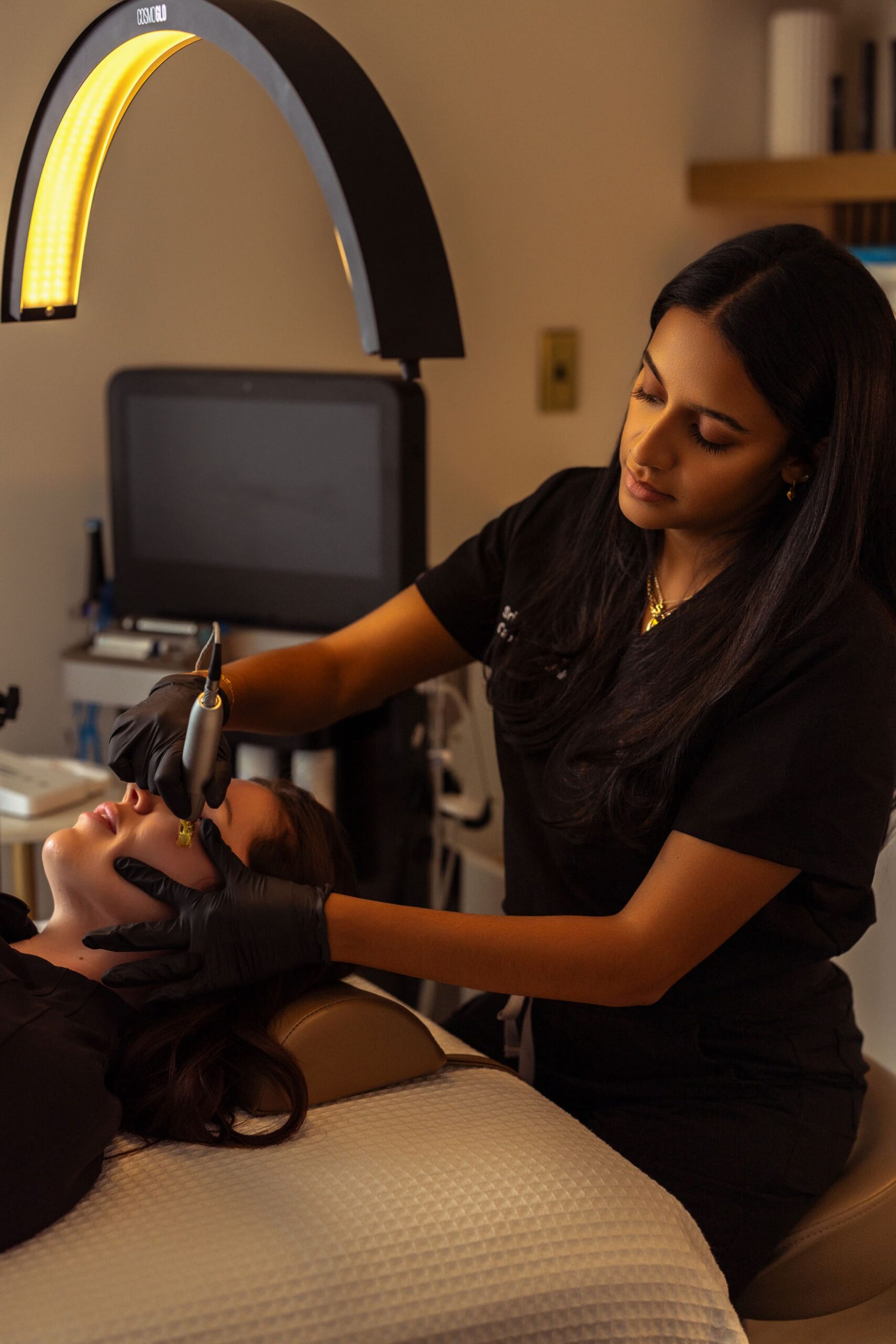 Photo of Srisha performing microneedling treatments on a patient