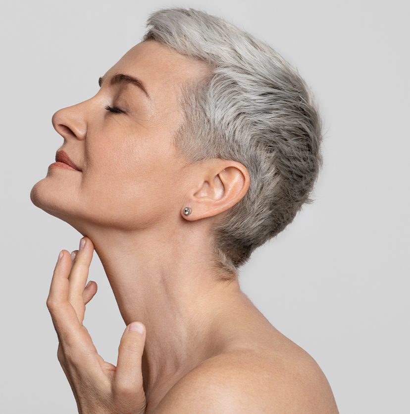 Photo of an older woman with short hair touching her neck