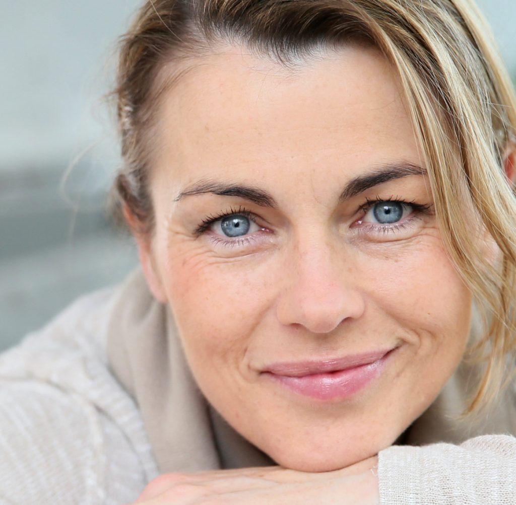 Woman with dirty blonde hair and blue eyes