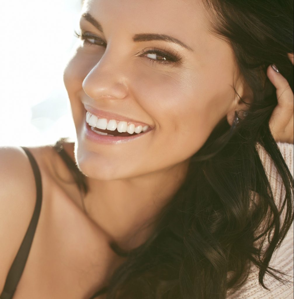 Photo of a smiling brunette wearing a black tank top