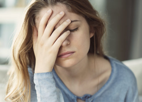 Woman with her hand over her face