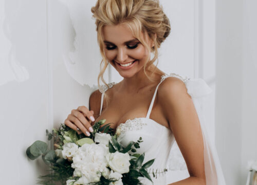 Bride in her dress holding a bouquet flowers during wedding season