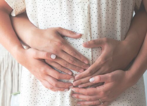 Photo of hands a woman's pregnant stomach