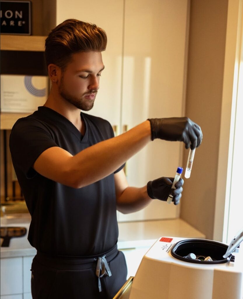 Photo of Rylie adding a vial of blood to the centrifuge