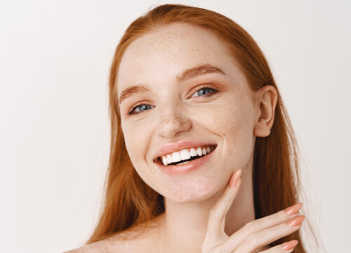 Photo of a woman with red hair and glowing skin