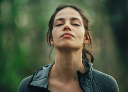 Photo of a healthy woman at peace out in the woods